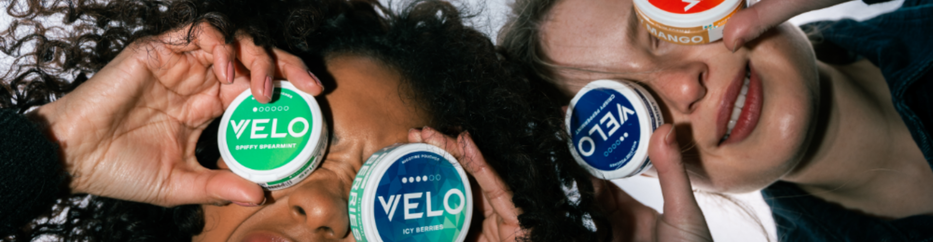 Two people choose VELO nicotine pouches from the many flavours available
